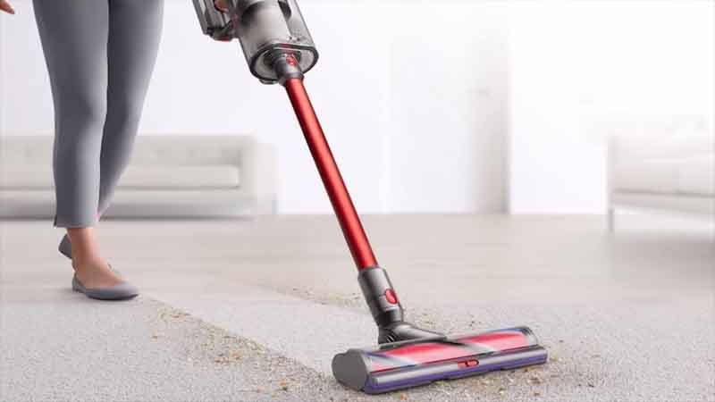 خانومی در حال استفاده از جارو شارژی روی فرش